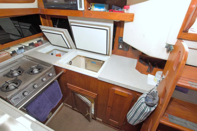 Slide: The Image of 1987 Morgan 43 CC yacht kitchen with stove, storage, and wooden cabinetry. - 35