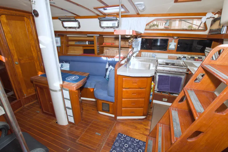 Slide: The Image of Interior of 1987 Morgan 43 CC sailboat with wooden furnishings and compact kitchen area. - 37