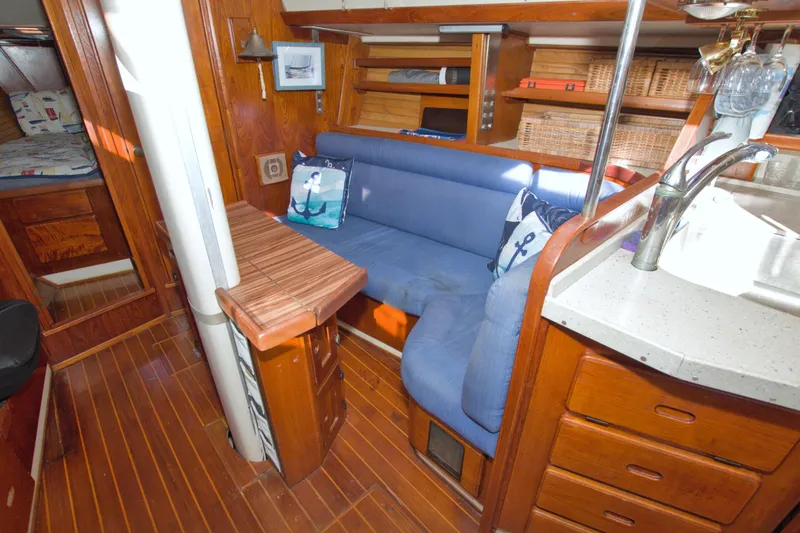 Slide: The Image of Interior of 1987 Morgan 43 CC yacht with blue seating and wooden finishes. - 38