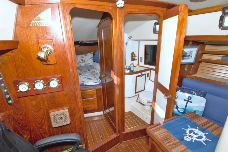 Slide: The Image of 1987 Morgan 43 CC yacht interior with wood paneling, cozy cabin, and nautical decor. - 42