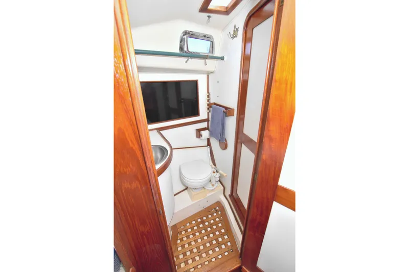Slide: The Image of 1987 Morgan 43 CC yacht bathroom with wooden accents and compact design. - 48
