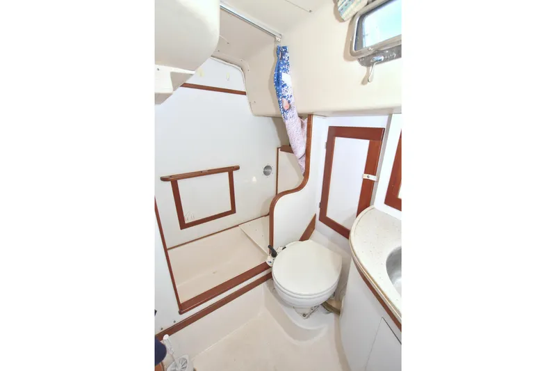 Slide: The Image of 1987 Morgan 43 CC yacht bathroom with white and wood accents, compact design. - 59