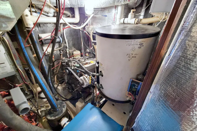 Slide: The Image of Engine room of a 1987 Morgan 43 CC sailboat, featuring mechanical components and wiring. - 65