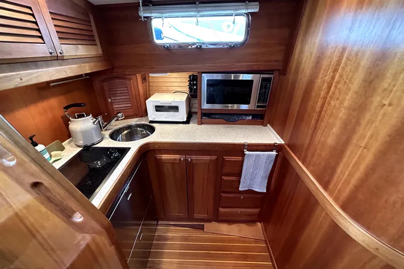 Slide: The Image of 2006 Sabre 38 Hard Top Express galley with wood cabinetry, sink, and appliances. - 14