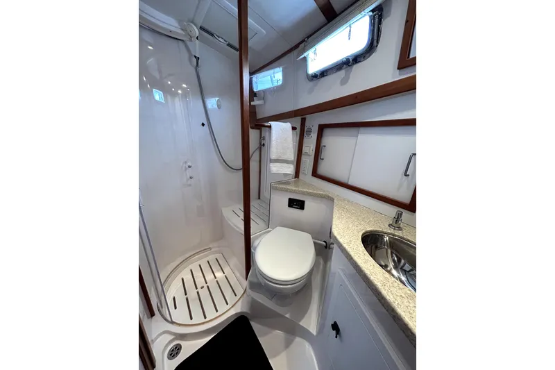 Slide: The Image of Bathroom interior of 2006 Sabre 38 Hard Top Express yacht, featuring shower, toilet, and sink. - 18
