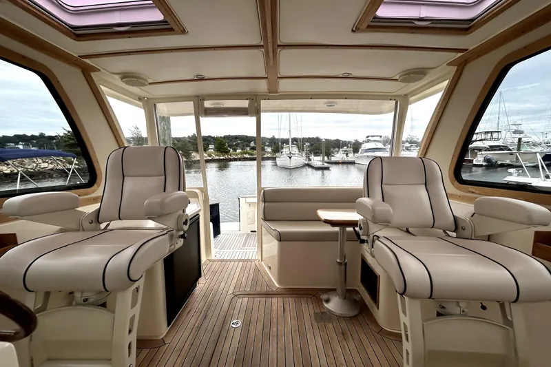 Slide: The Image of Interior of 2006 Sabre 38 Hard Top Express yacht with luxurious seating and scenic marina view. - 7