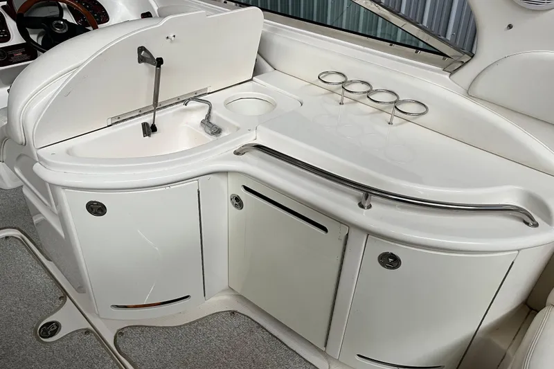 Slide: The Image of 2003 Sea Ray 290 Bowrider boat interior with sink and cup holders. - 10