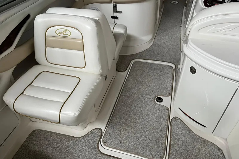 Slide: The Image of Interior of a 2003 Sea Ray 290 Bowrider with white seating and carpeted flooring. - 12