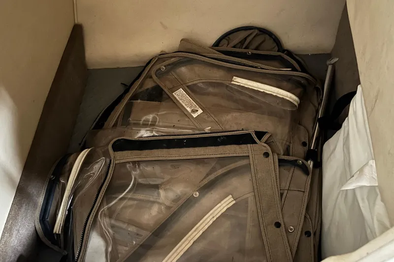 Slide: The Image of Stored boat covers in a 2003 Sea Ray 290 Bowrider cabin space. - 25