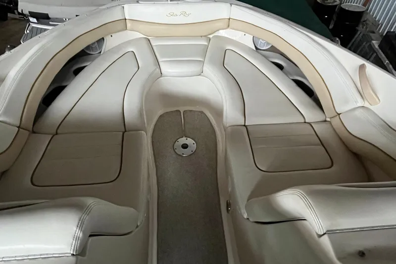 Slide: The Image of 2003 Sea Ray 290 Bowrider interior with beige seating and spacious layout. - 26