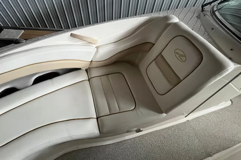 Slide: The Image of 2003 Sea Ray 290 Bowrider interior seating with beige upholstery and logo. - 27