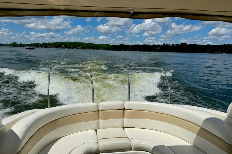 Slide: The Image of 2003 Sea Ray 290 Bowrider cruising on a lake under a partly cloudy sky. - 33