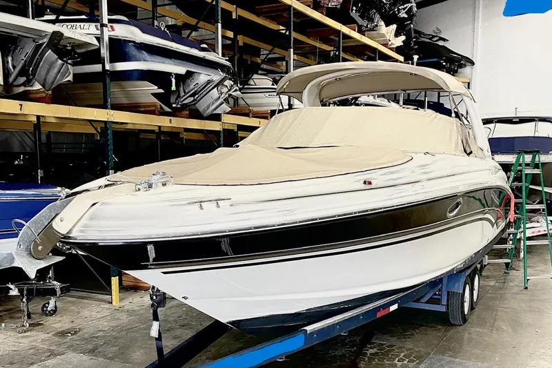 Slide: The Image of 2003 Sea Ray 290 Bowrider boat in indoor storage, covered and on a trailer. - 34