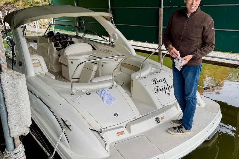 Slide: The Image of Man cleaning a 2003 Sea Ray 290 Bowrider boat named "Bay Tripper" at a dock. - 4