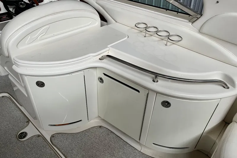 Slide: The Image of 2003 Sea Ray 290 Bowrider interior with sleek white cabinetry and cup holders. - 9