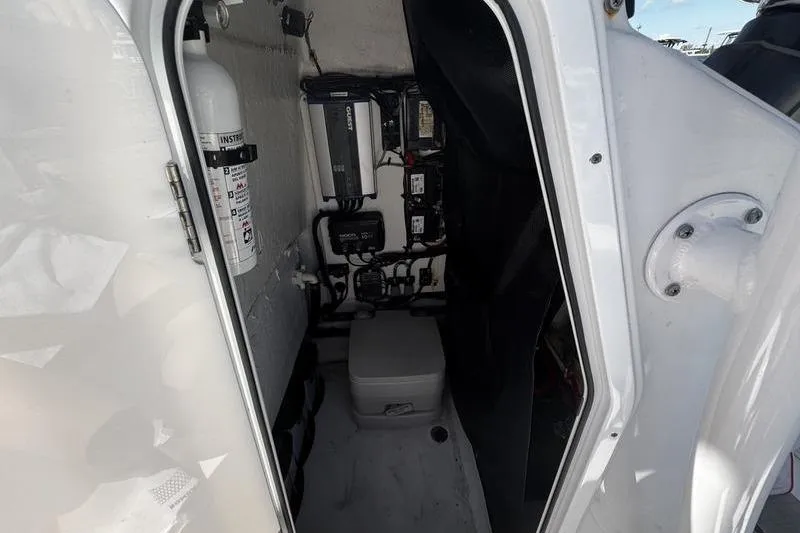 Slide: The Image of 2024 SPORTMAN MASTERS 227 boat interior with fire extinguisher and electrical components. - 16