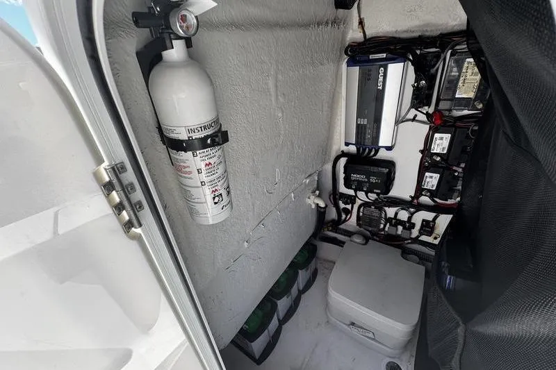 Slide: The Image of 2024 SPORTMAN MASTERS 227 boat interior with fire extinguisher and electrical components. - 17