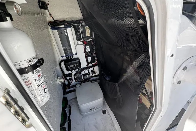 Slide: The Image of 2024 SPORTMAN MASTERS 227 boat interior with fire extinguisher and electrical components. - 18