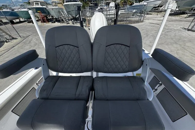 Slide: The Image of 2024 SPORTMAN MASTERS 227 boat seats with diamond-pattern upholstery in a marina setting. - 21