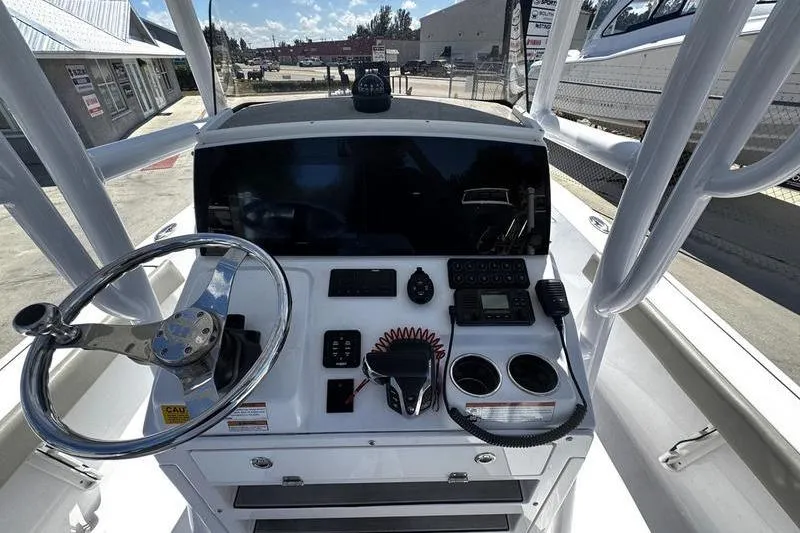 Slide: The Image of 2024 SPORTMAN MASTERS 227 boat dashboard with steering wheel and controls. - 23