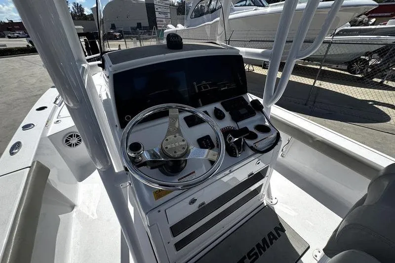 Slide: The Image of 2024 SPORTMAN MASTERS 227 boat console with steering wheel and controls. - 24