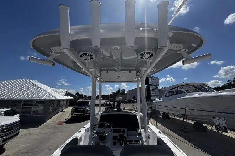 Slide: The Image of 2024 SPORTMAN MASTERS 227 boat with T-top and rod holders under sunny sky. - 29