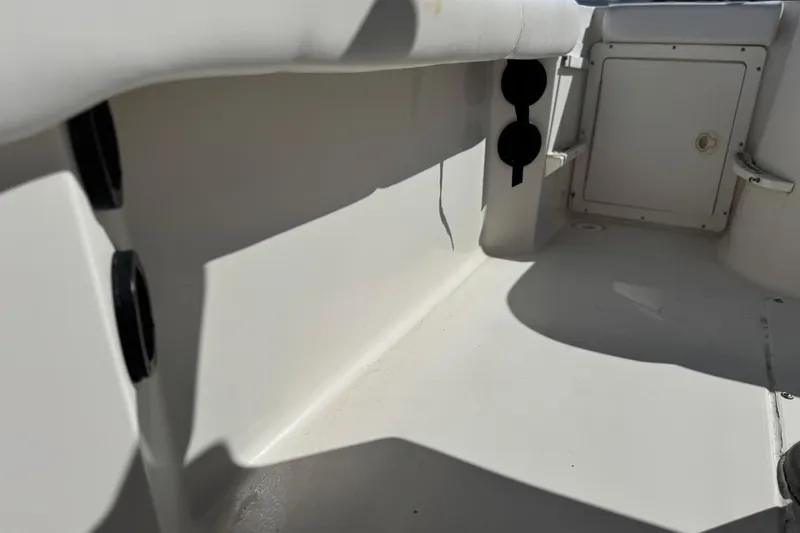 Slide: The Image of 2006 Seaswirl Striper 1851 Center Console interior, featuring storage compartments and rod holders. - 16