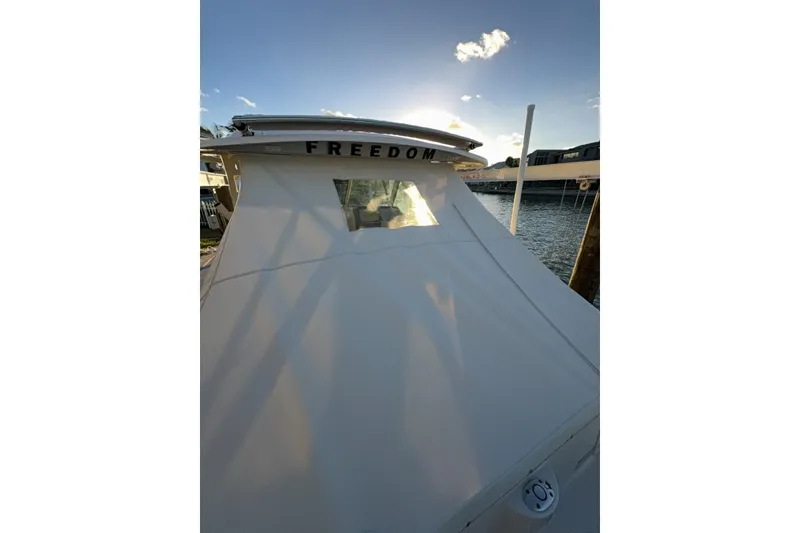 Slide: The Image of 2026 Grady-White Freedom 325 boat docked at sunset, showcasing sleek design. - 15