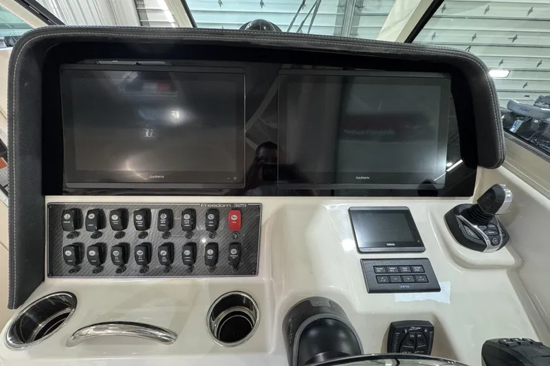 Slide: The Image of Control panel of 2026 Grady-White Freedom 325 boat with Garmin displays and switches. - 3
