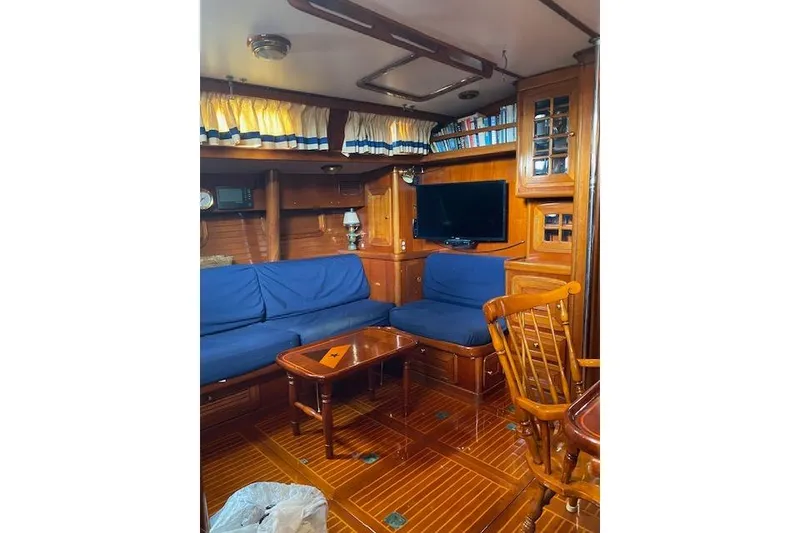 Slide: The Image of Interior of 1990 Little Harbor Sloop 58' with wooden furnishings and blue seating. - 10