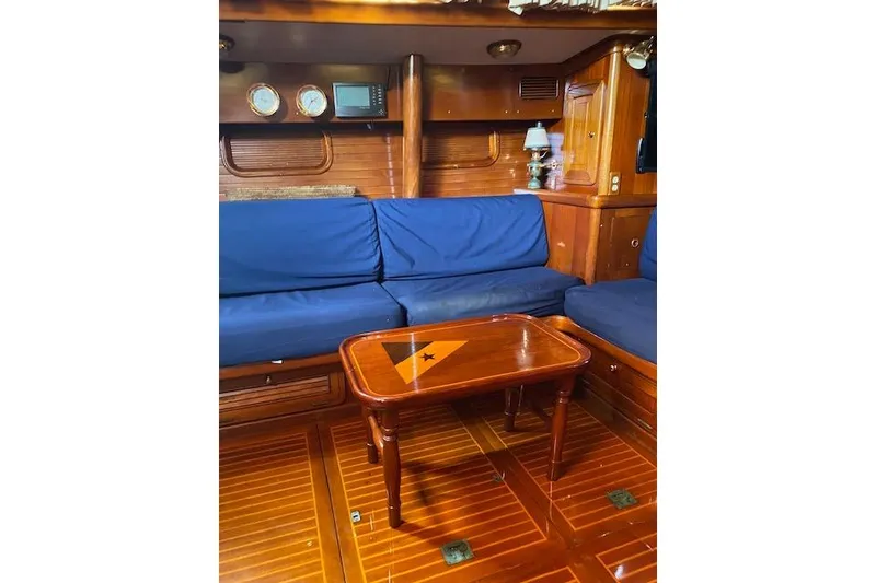 Slide: The Image of Interior of 1990 Little Harbor Sloop 58' with wooden furnishings and blue seating. - 12