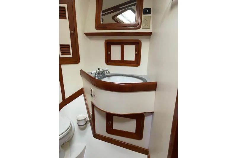 Slide: The Image of Interior of 1990 Little Harbor Sloop 58' bathroom with wooden trim and sink. - 19