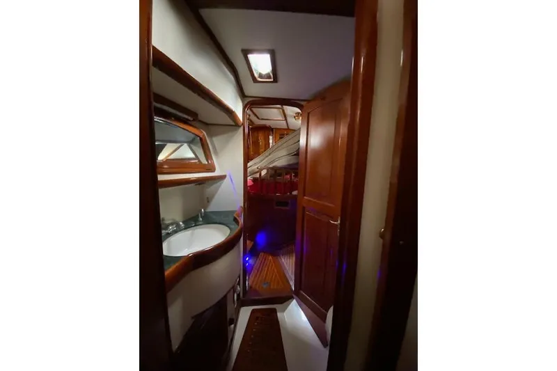 Slide: The Image of Interior of 1990 Little Harbor Sloop 58' with wooden cabinetry and cozy lighting. - 26