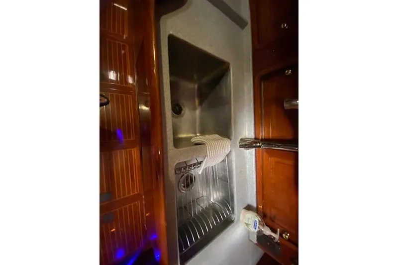 Slide: The Image of 1990 Little Harbor Sloop 58' yacht kitchen sink with wooden cabinetry and modern fixtures. - 36