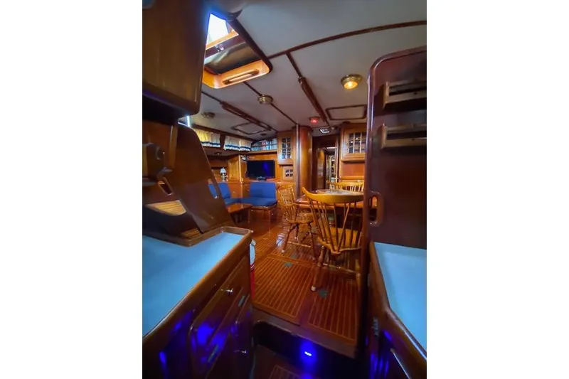 Slide: The Image of Interior of 1990 Little Harbor Sloop 58' with wooden furnishings and blue accents. - 38