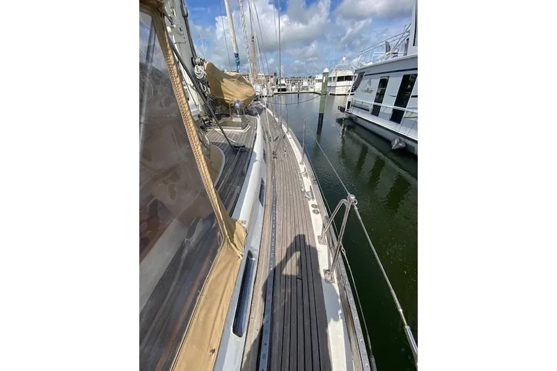 Slide: The Image of 1990 Little Harbor Sloop 58' docked, showcasing teak deck and marina view. - 43