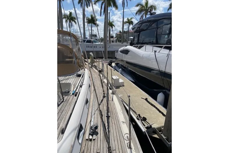 Slide: The Image of 1990 Little Harbor Sloop 58' docked beside modern yacht, surrounded by palm trees. - 51