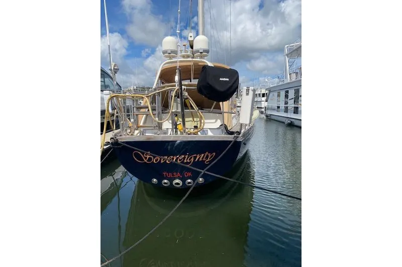 Slide: The Image of 1990 Little Harbor Sloop 58' docked, named "Sovereignty," with clear skies and calm waters. - 60