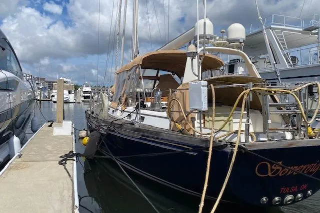 Slide: The Image of Little Harbor Sloop 58' yacht docked at marina, 1990 model, under a partly cloudy sky. - 61