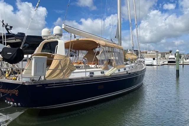 Slide: The Image of 1990 Little Harbor Sloop 58' yacht docked in a marina under a blue sky. - 62