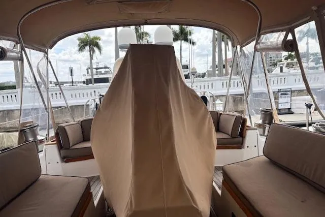 Slide: The Image of 1990 Little Harbor Sloop 58' cockpit with covered helm, docked near palm trees. - 68
