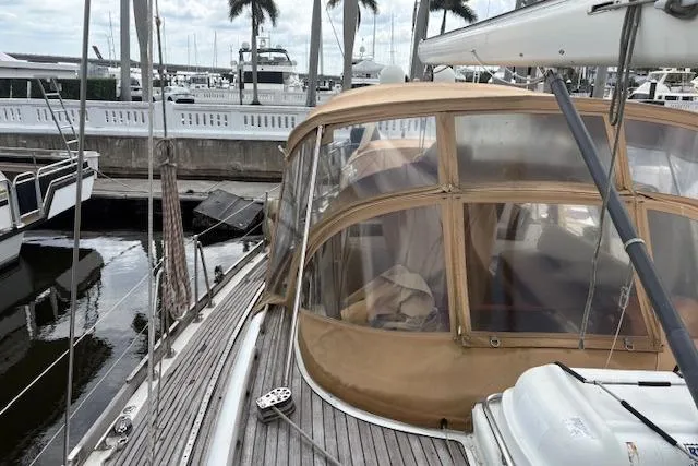 Slide: The Image of 1990 Little Harbor Sloop 58' docked, featuring a tan canopy and wooden deck. - 70