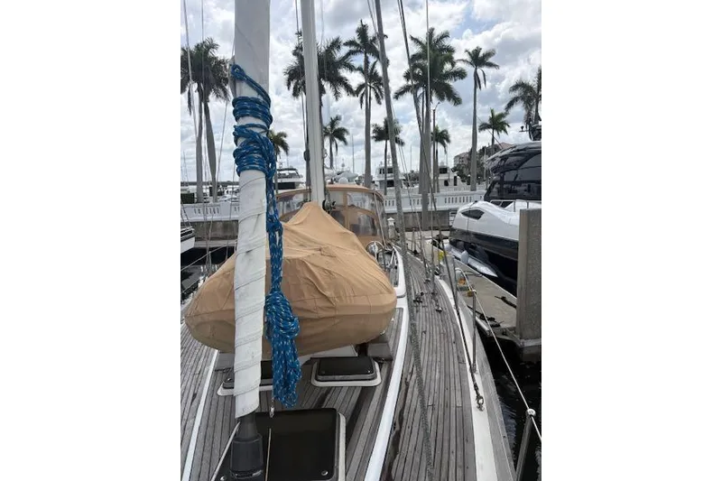 Slide: The Image of 1990 Little Harbor Sloop 58' docked, with palm trees and cloudy sky in background. - 71
