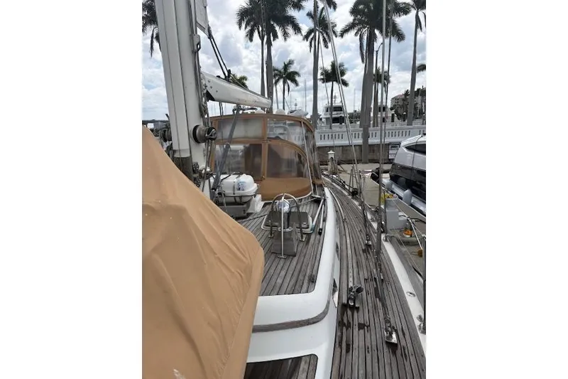 Slide: The Image of 1990 Little Harbor Sloop 58' docked, featuring teak deck and palm trees in background. - 72