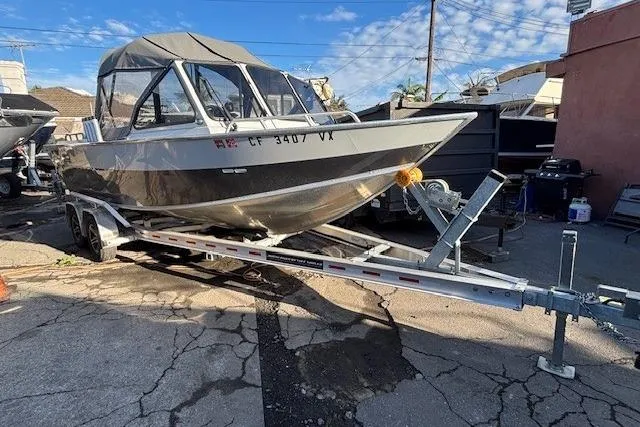The Image of 2023 North River 23' Seahawk boat on trailer, parked outdoors under blue sky. - 0