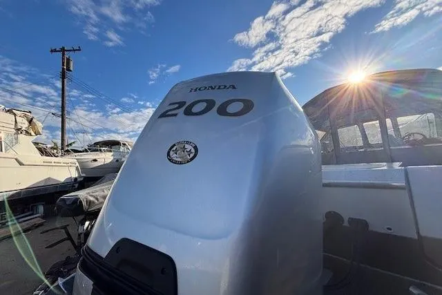 Slide: The Image of 2023 North River 23' Seahawk with Honda 200 engine under a bright blue sky. - 10