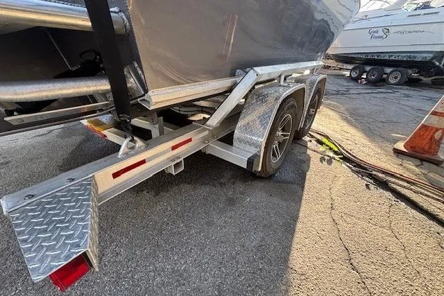 Slide: The Image of 2023 North River 23' Seahawk boat on a dual-axle trailer in a parking area. - 11