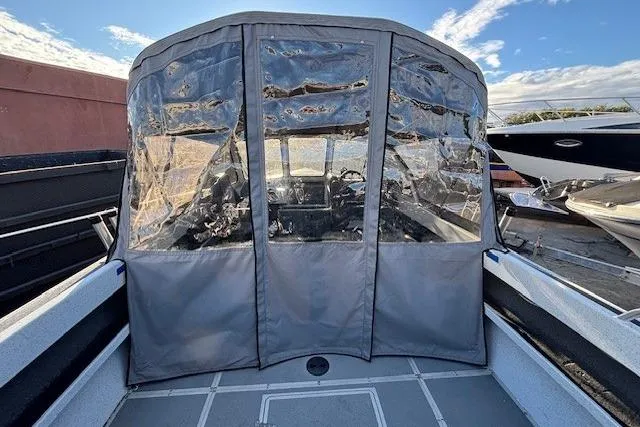 Slide: The Image of 2023 North River 23' Seahawk boat with protective canopy, docked under a clear sky. - 12