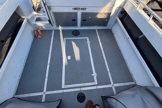 Slide: The Image of 2023 North River 23' Seahawk boat deck with storage compartments and seating. - 14