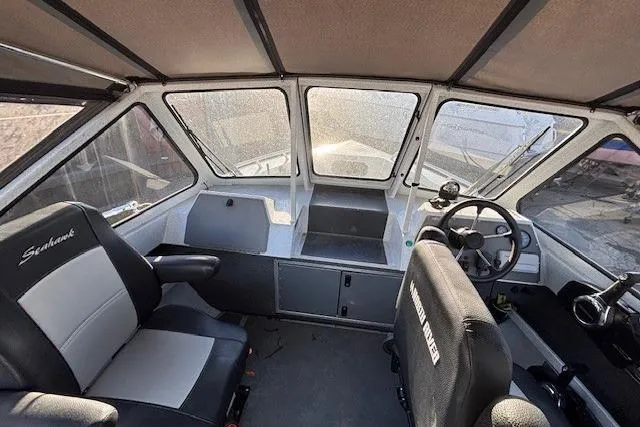 Slide: The Image of Interior of 2023 North River 23' Seahawk boat with steering wheel and seating. - 19